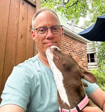 Don Scott Schnure, owner of Integrity Land Group, holding his dog